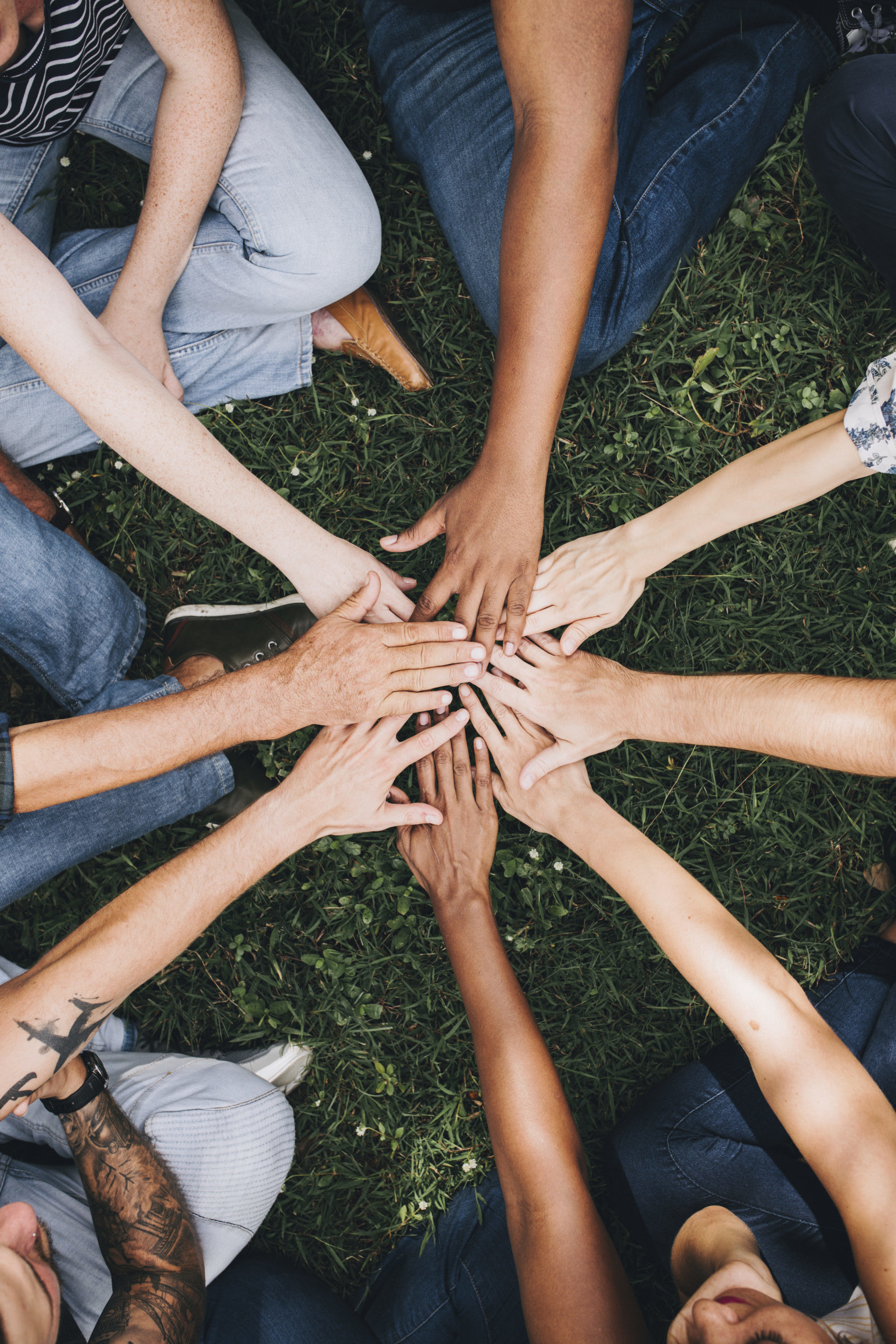 People stacking hands together in the park